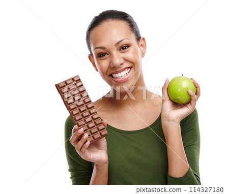 Portrait, happy woman and chocolate versus apple for health, wellness and diet benefits. Smile, person and choice of candy, fruits and organic food challenge for nutritional balance in studio Portrait, happy woman and chocolate versus apple for health, wellness and diet benefits. Smile, person and choice of candy, fruits and organic food challenge for nutritional balance in studio 114327180