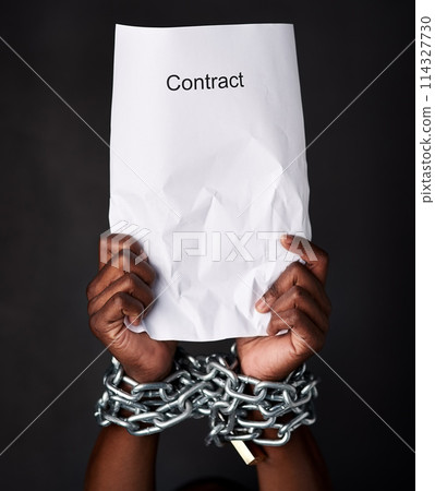 Hands, chains and document for contract, legal and law with employment and modern slavery. Person, closeup or worker with paperwork, scam or agreement with corporate bondage on dark studio background 114327730