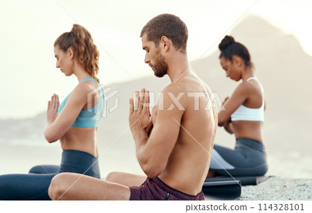 Fitness, meditation and yoga with people on beach for mental health, peace or wellness in morning. Exercise, training and zen with sporty friends on mat at coast by ocean for balance and mindset 114328101