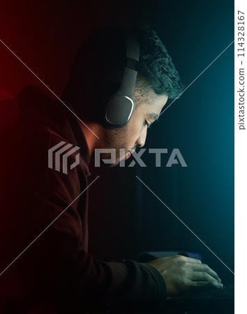 Esports, man and gamer on computer at night for competition in rpg video games or virtual challenge. Gaming, nerd and hacker typing in dark for cyber contest in home with neon light or tech mockup 114328167