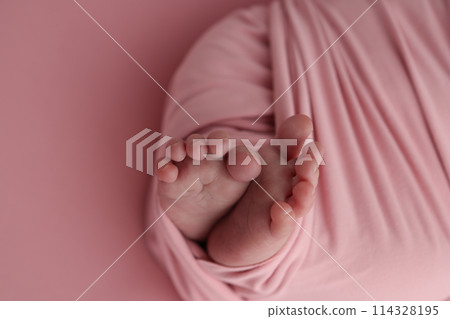 Close-up of tiny, cute, bare toes, heels and feet of a newborn girl, boy. Baby foot on pink soft coverlet, blanket. Detail of a newborn baby legs. Macro horizontal professional studio photo.  114328195