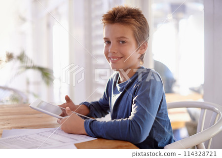 Child, homework and tablet on table in portrait, school work for learning and educational development on technology. Digital search, internet and online help in home, happy and smile on studying kid 114328721