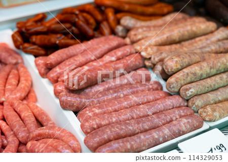 Different types of sausages laid out in showcase of butcher shop 114329053