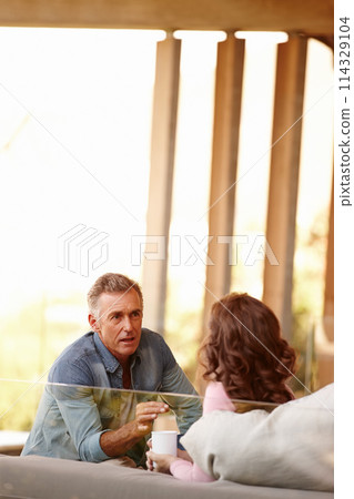 Mature couple, talking and planning in living space with coffee, bonding and discussing life and marriage in day. Older man, woman and couch at home with together, important and serious conversation 114329104