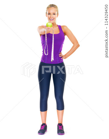 Woman, smile and portrait with apple and measuring tape for detox, diet and fitness on white background. Model, nutritionist or dietician isolated with fruit for weightloss, health and vitamins 114329450