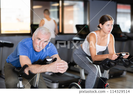 Elderly man exercising on exercise bike Elderly man exercising on exercise bike 114329514