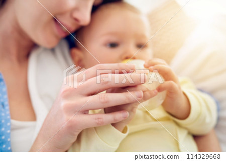 Bottle, hands or mother with baby in home drinking milk for wellness with kid, care or food nutrition. Parent, woman or single mom in family house for bonding, formula or feeding with newborn child 114329668