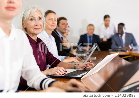 Elderly business woman using laptop at business meeting Elderly business woman using laptop at business meeting 114329882