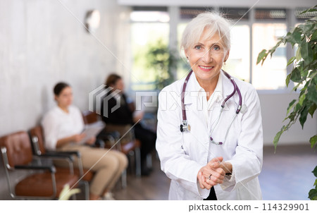 Friendly elderly female doctor inviting to medical office 114329901