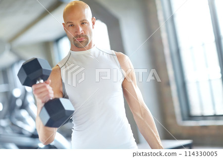 Man, weight lifting and training in gym for fitness with dumbbell, exercise challenge and strong muscle. Bodybuilder, pro athlete and strength workout with concentration and serious for competition 114330005