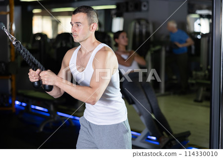 Young man training with straps in gym Young man training with straps in gym 114330010