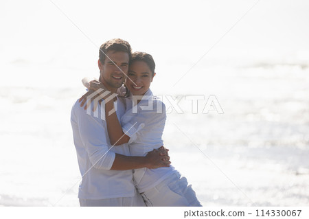 Travel, hug and portrait of couple on beach for bonding, relax together and relationship by ocean. Dating, happy and man and woman embrace for romance on holiday, vacation and weekend in nature 114330067
