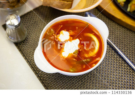 Russian meat soup solyanka with assorted meat and sausages and vegetables Russian meat soup solyanka with assorted meat and sausages and vegetables 114330136