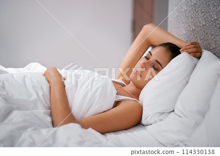 Bedroom, sleep and woman in bed at house, home and hotel to relax, rest and dreaming with duvet in Cape Town. Female person, lady and tired with pillow, blanket and eyes closed comfortable in nap 114330138