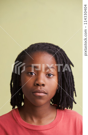 African boy, portrait and fashion in studio with creative, style and confidence on a yellow background. Face of young and cool model, student or teenager in natural hair and casual or trendy t shirt 114330404