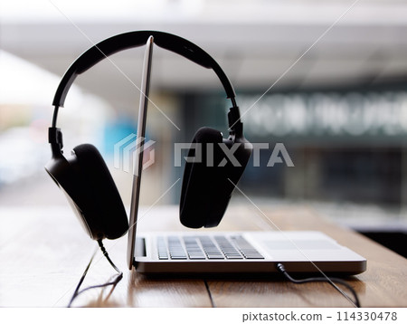 Laptop, work and headphones closeup on table at cafe or coffee shop for productivity online. Internet, streaming and computer on desk on campus at college or university with technology to study Laptop, work and headphones closeup on table at cafe or coffee shop for productivity online. Internet, streaming and computer on desk on campus at college or university with technology to study 114330478
