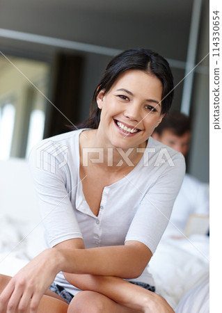 Woman, happy and portrait in bedroom in house with smile for vacation, marriage and love. Female person, couple and confidence together in apartment with bed in morning for relax, break and holiday 114330654