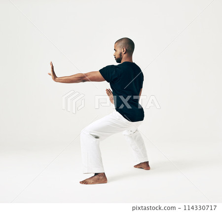 Man, studio and martial arts for defense practice, action and karate exercise on white background. Black male person, mockup space and training for combat, fight and position of attack in taekwondo Man, studio and martial arts for defense practice, action and karate exercise on white background. Black male person, mockup space and training for combat, fight and position of attack in taekwondo 114330717
