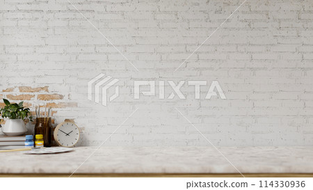 A white marble tabletop features painting tools and a space against the white brick wall. 114330936