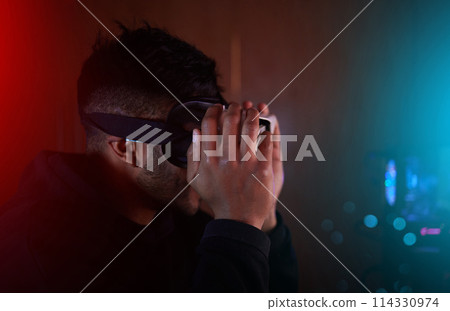 Pro gamer, man and night with vr in home, dark and futuristic tech for streaming, challenge and metaverse. Person, augmented reality and glasses for gaming, esports and competition on web in house 114330974