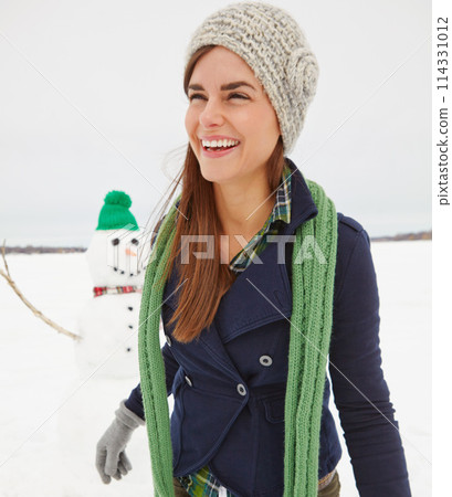 Woman, snowman and smile in nature on holiday with thinking, clothes and adventure in cold. Person, snow sculpture and memory with playful creativity in countryside at vacation resort in Switzerland 114331012