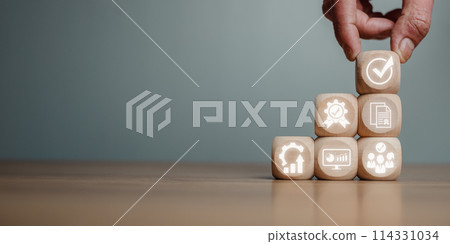 QA, Quality management assurance concept, Hand holding wooden block on desk with quality management assurance icon on virtual screen. QA, Quality management assurance concept, Hand holding wooden block on desk with quality management assurance icon on virtual screen. 114331034