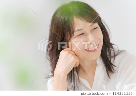 A middle-aged woman wearing a white shirt and smiling 114331135