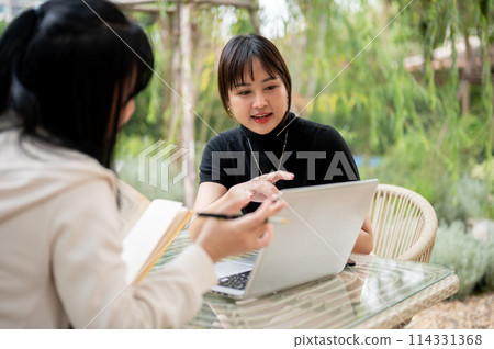 An Asian woman working remotely in a garden with her colleague, discussing work and sharing ideas. An Asian woman working remotely in a garden with her colleague, discussing work and sharing ideas. 114331368