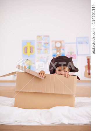 Home, portrait or costume as pirate to play in boat boxes or fantasy in bedroom or house. Kid hiding, child captain or boy in an adventure game with cardboard or monocular telescope to sail on ship Home, portrait or costume as pirate to play in boat boxes or fantasy in bedroom or house. Kid hiding, child captain or boy in an adventure game with cardboard or monocular telescope to sail on ship 114331514