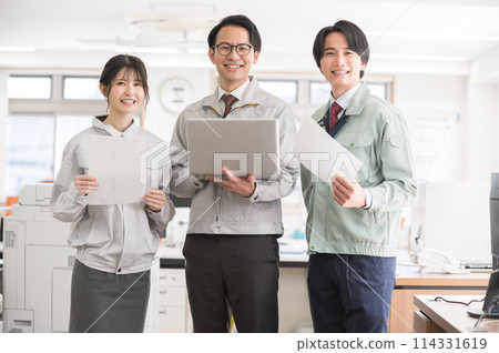 Three male and female engineers in work clothes Three male and female engineers in work clothes 114331619