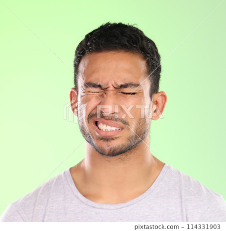 Migraine, man and pain with hurt from headache with stress and anxiety in a studio. Brain fog, tension and mistake with casual fashion and modern style with problem and issue with green background Migraine, man and pain with hurt from headache with stress and anxiety in a studio. Brain fog, tension and mistake with casual fashion and modern style with problem and issue with green background 114331903