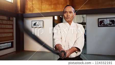Japanese master, aikido and training with sword, modern martial arts and teacher of self defence. Sensei, black belt or katana in dojo place, sport or weapon demonstration by mature fighter in combat 114332191