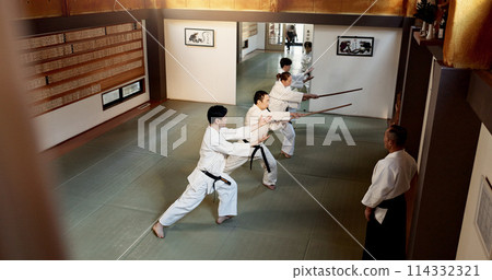 Aikido students, stick or learning martial arts in dojo for practice, movement or self defense. Combat demonstration, above or Japanese people in training workout for fighting, education or sensei Aikido students, stick or learning martial arts in dojo for practice, movement or self defense. Combat demonstration, above or Japanese people in training workout for fighting, education or sensei 114332321