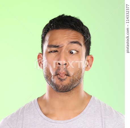 Man, funny and comic face in studio with silly, goofy and emoji mouth with fun attitude for humor. Model, person and facial expression for comedy, joke and confidence with mockup on green background 114332377