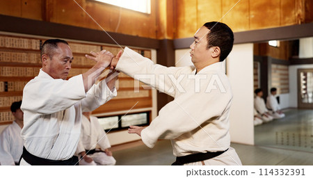 Japanese master, black belt student and learning martial arts in dojo place in fight and aikido class of self defence. Commitment, battle and fitness in skill, combat and sport discipline in respect 114332391