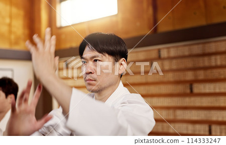 Japanese student, aikido or training martial arts in dojo for practice, fighting education or self defense. Combat routine, wellness or male person with workout, body movement and class with peace Japanese student, aikido or training martial arts in dojo for practice, fighting education or self defense. Combat routine, wellness or male person with workout, body movement and class with peace 114333247