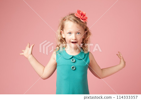 Female child, shocked and fashion with portrait, amazed and arms open by background. Young girl, surprised and wow in studio with dress, cute and omg expression for excitement in casual clothing 114333357