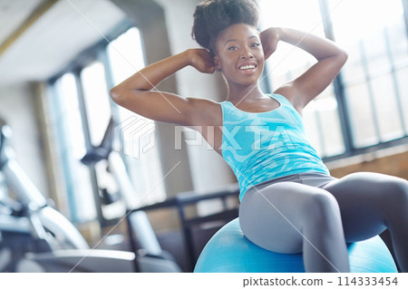 Ball, sit ups or black woman in gym training abs for six pack muscles or strong stomach in exercise. Smile, fitness and happy athlete in studio for core strength, abdomen or body workout for wellness Ball, sit ups or black woman in gym training abs for six pack muscles or strong stomach in exercise. Smile, fitness and happy athlete in studio for core strength, abdomen or body workout for wellness 114333454