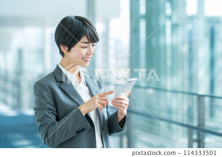 A business woman with a smartphone. 114333501