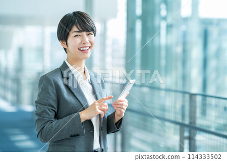 A business woman with a smartphone. 114333502