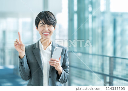 A business woman with a smartphone. 114333503