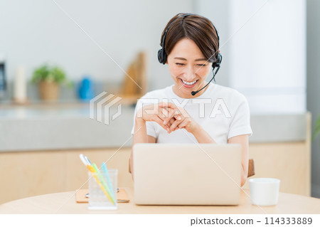 在客廳遠程辦公的中年婦女。 在客廳遠程辦公的中年婦女。 114333889