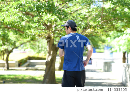 Back view of a young man jogging outdoors Back view of a young man jogging outdoors 114335305