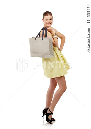 Woman, shopping bag and fashion in studio with discount, package and gift for spring sale on a white background. Portrait of excited person, customer or model with retail, present and luxury in heels 114335484