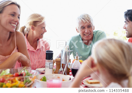 Family, food and conversation with lunch at table for relationship for relax with healthy eating for wellness. People, meal and celebration for easter with holiday for gathering with nutrition 114335488