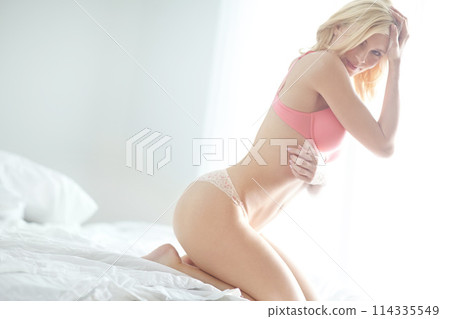 Girl, lingerie and bed with portrait in morning for healthy body, confidence and happy to relax. Woman, person and wake up in underwear, holiday and pride in hotel room, resort and lodge in Berlin 114335549