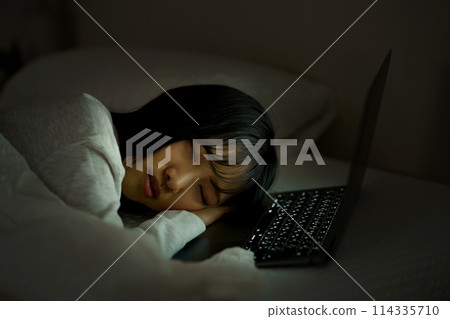 Young woman spending her time in bed Young woman spending her time in bed 114335710