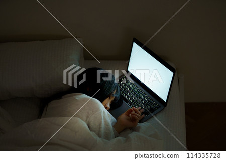 Young woman spending her time in bed Young woman spending her time in bed 114335728