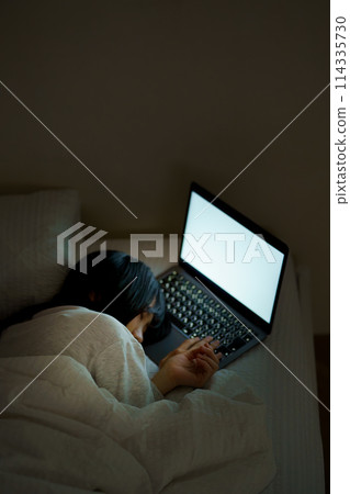 Young woman spending her time in bed 114335730