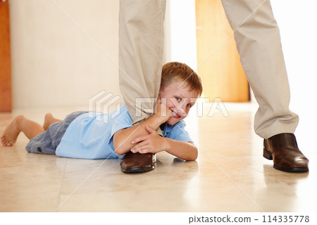 Leg, child and holding on parent in portrait, play and hanging on father for game on floor in home. Male person, kid and relax on tile or clinging for support, boy and smile for funny joke or happy 114335778